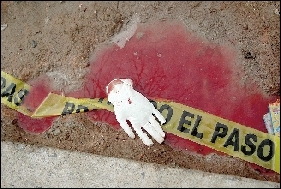 1月31日,在墨西哥华雷斯凶杀现场,一只白色的手套落在沾有血迹的水洼