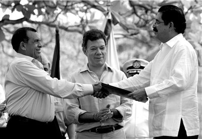 22日,洪都拉斯总统洛沃(左)与前总统塞拉亚(右)签署协议.图/人民图片