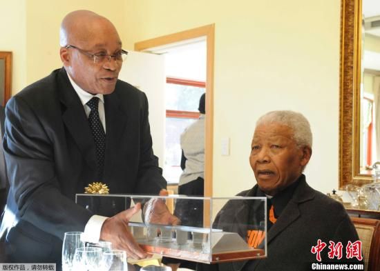 2011年7月18日，南非前总统曼德拉在家中庆祝93岁的生日。图为南非现任总统祖玛向前总统曼德拉赠送生日礼物。