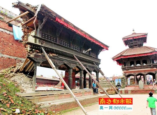  尼泊尔的巴德岗古城，在地震中受损的古迹旁放置了建筑的原貌照片。