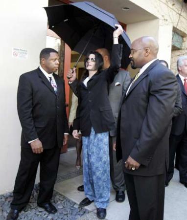 Pop star Michael Jackson adjusts his umbrella while departing the Santa Barbara County Superior Court in this file photo taken on March 10, 2005 in Santa Maria, California. [Agencies]