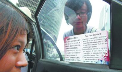 实行时距并计之后，沈城出租车窗户上粘贴的新的计价收费标准标签中，部分英文说明不够准确，容易让人误解。 记者 王迪 摄