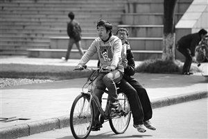 大二男生单车接送残疾同学风雨无阻(图)