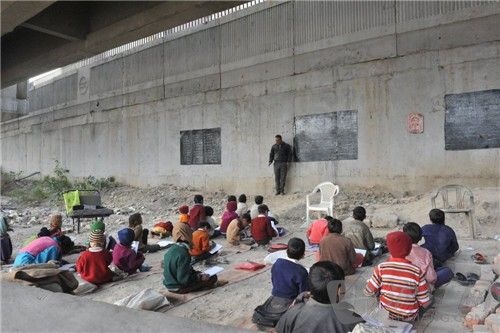 13. In New Delhi, India, poverty-stricken children receive free education from volunteer teachers under the bridge. ӡȵµƶͯ־ԸʦΡ