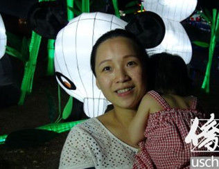 蒋女士抱着女儿在洛县博览会观赏中秋花灯。(美国《侨报》/高睿 摄)