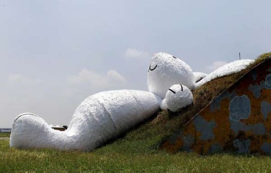 A 25.3-meter-long giant rabbit designed by Dutch artist Florentijn Hofman is displayed at an old aircraft hangar as part of the Taoyuan Land Art Festival in Taoyuan, northern Taiwan, Sept 3, 2014. [Photo/Agencies]