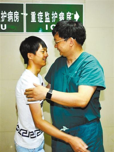 昨日，19岁的谷桥(左)拥抱救过自己的医生。 重庆晨报记者 甘侠义 摄 