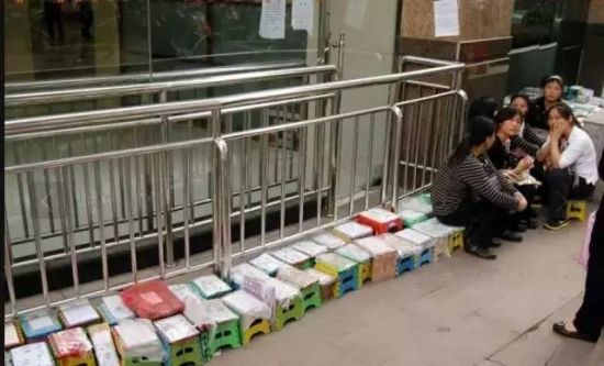 2011年9月26日，江苏省中医院门诊楼外，很多患者或家属用自制的“小板凳号”排队，只为等着能挂上专家号。小板凳上写有名字。(图片来源凤凰网)