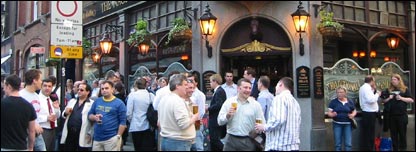 People standing outside a busy pub