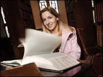 A woman reading a large dictionary