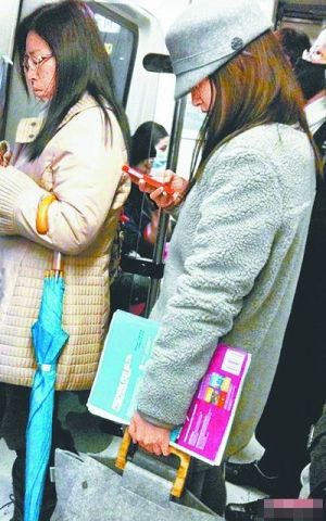 林依晨搭捷运左手还夹着英文书。