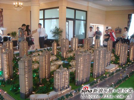图为前来看房的意向客户在盛和世纪的沙盘前观望
