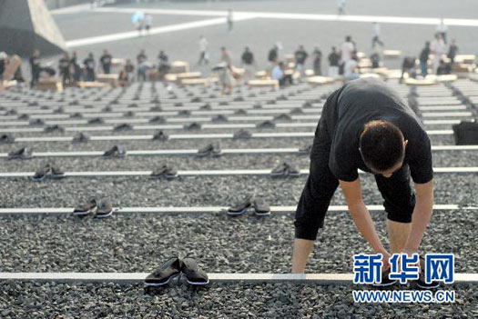 8月14日，人们将布鞋整齐地摆放在广场上。新华社发