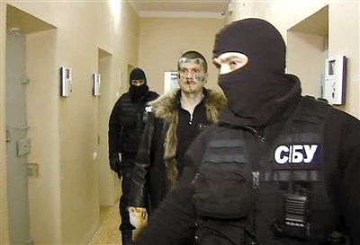 俄国家电视一台截屏图。中间男子为被捕的嫌疑人亚当·奥斯马耶夫，前后都是乌克兰特工。