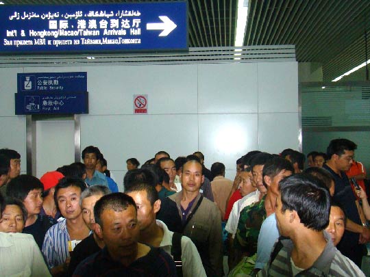 图1：撤回中国员工整队离开机场。摄影：杨元春