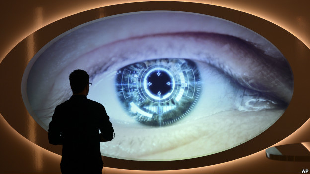 A man watches a screen that shows an eye being scanned at Germany's spy museum.