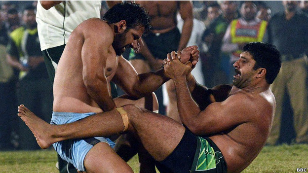 Kabaddi players grip each other