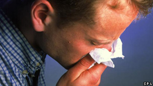 A man blowing his nose on a tissue