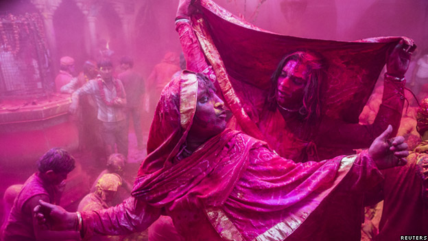 Men covered in pink powder during festival of Lath mar Holi in Northern India