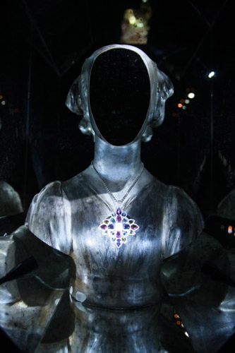 八角形镜面里的镜面铜像佩戴着CHANEL顶级珠宝“圣马可系列”胸针，亦可作为链坠