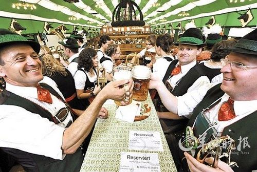 People dressed in traditional costumes toast Munich Beer Festival