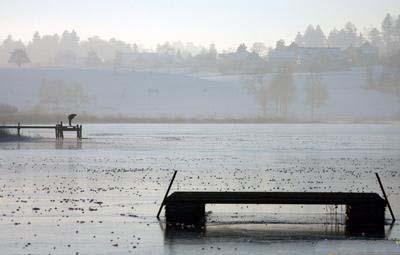4、1月13日，瑞士苏黎世，一名男子察看部分冰封的湖面。