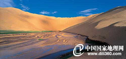 沙子泉是库木库里沙漠中的奇特景观。一抹浅绿、一湾溪水、一条河谷、一座巨大的沙山，沙子泉，把水与沙统一于蓝天碧空之下。