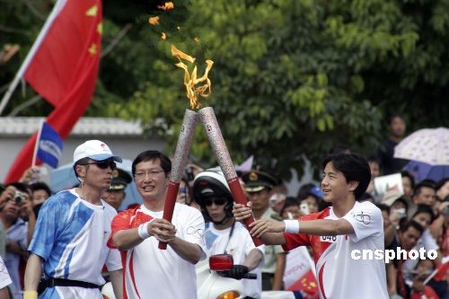 图文北京奥运圣火在三亚传递火炬交接一瞬间