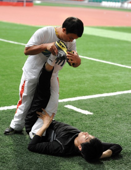 图文-刘翔备战多哈世界室内田径锦标赛 压腿训练