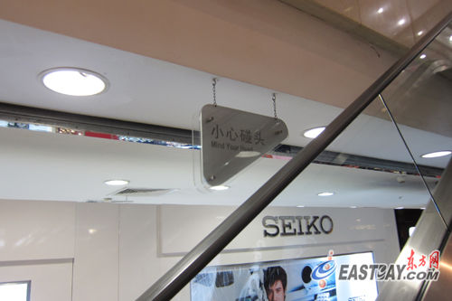 商场自动扶梯形成的夹角间,大多都悬挂着"小心碰头"的提示牌.