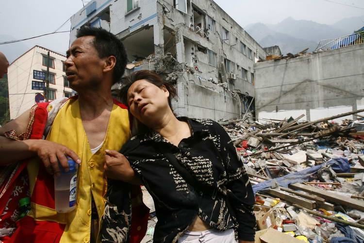 2008年5月16日,汶川映秀镇,一对夫妇在地震中被毁的房屋前悲痛万分.