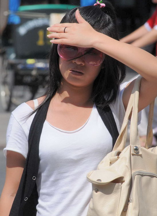 图文:女孩儿戴着墨镜用手遮住阳光