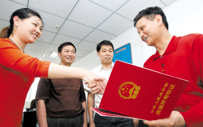 昨日,九龙坡区毛线沟,领回房产证等证据材料的李光平紧握着公交员工的