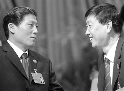 市检察院检察长慕平(左)和市高级人民法院院长池强(右)相互交谈.