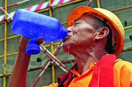 黑 北 路一 建 筑工 地 上︐ 一位工 人拿起水杯大口地喝水解渴︒泉城