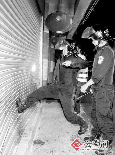 警察使劲踹门 记者 黄雪飞 摄被收缴的仿真枪赌场配"枪" 警察夜袭当场