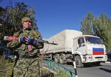 在乌克兰顿涅茨克,一名民间武装人员护卫载有俄罗斯援助物资的卡车