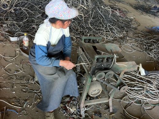 石角鎮馬頭村的一家小作坊內, 工人正在用機器剝銅線