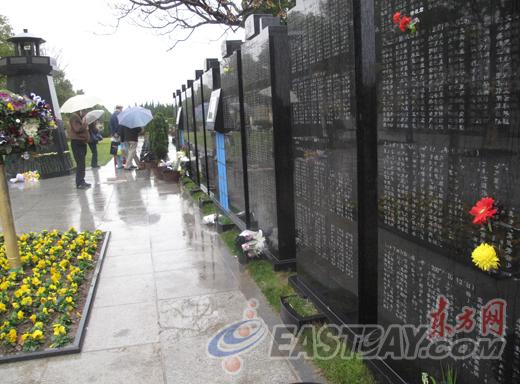 图片说明:家属在纪念碑前缅怀已故的亲人.