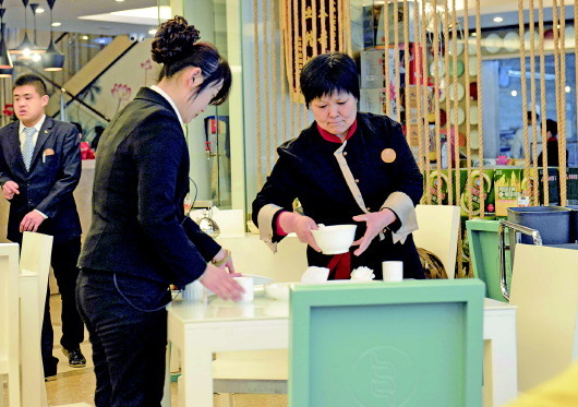 24日,济南某餐厅服务员(右一)正在收拾桌子,记者走访多家餐厅发现