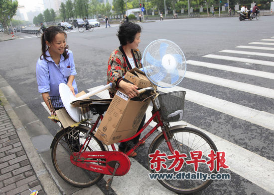 昨天,瑞金南路,市民用自行车推着新买的风扇过马路.早报记者 王炬亮