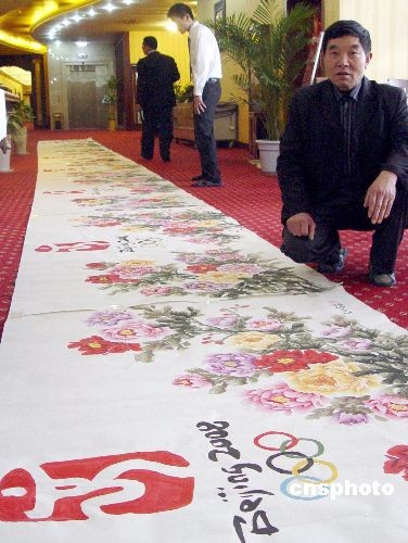 河南省书画专业委员会画师王小召在展示其创作的迎奥运牡丹图