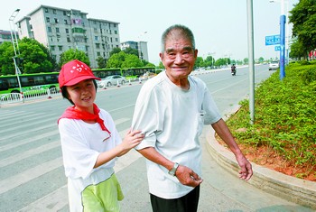 在营盘路上,开福区新风街小学的学生志愿者正热情搀扶老人过马路.