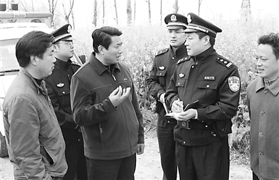 图为胡念东(右二)在村里走访农村赌博难禁,这是很多在农村工作的民警
