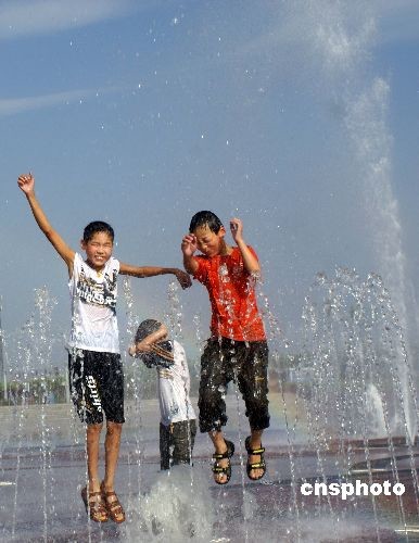 6月21日,河南省济源市少年在世纪广场玩水避暑
