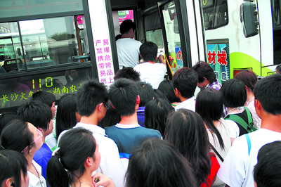 在长沙火车站旁的公共汽车站,众多市民毫无秩序地拥上一辆110路公交
