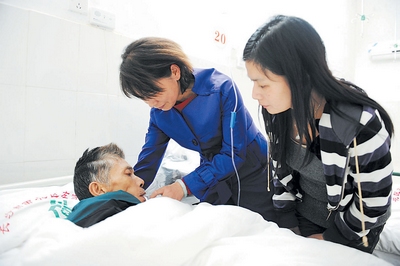 昨晚,王公塘社区主任唐金娥正在为病床上的赵和平(左一)喂药
