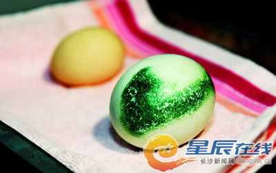 这枚受精的企鹅蛋蛋壳上有一抹青绿色,个头比鸡蛋大很多.