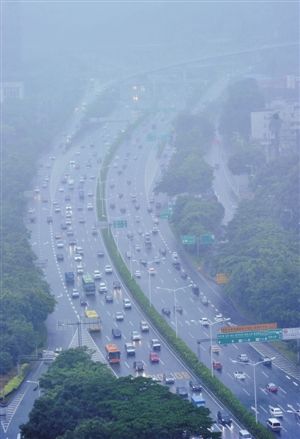 右圖:昨日上午,北環大道被大雨籠罩,視線受阻,車輛龜速通行.