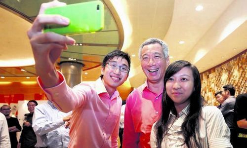 两名新加坡理工学院生林宇颉(左)和谢慧仪(右)在论坛结束后找李显龙